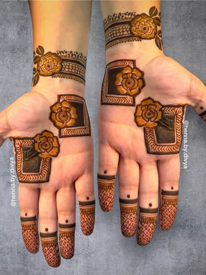 A modern take on party mehendi, this design uses geometric frames to highlight bold, shaded roses on the palms. The fingertips feature a simple crosshatch pattern, creating a contemporary and stylish look.
