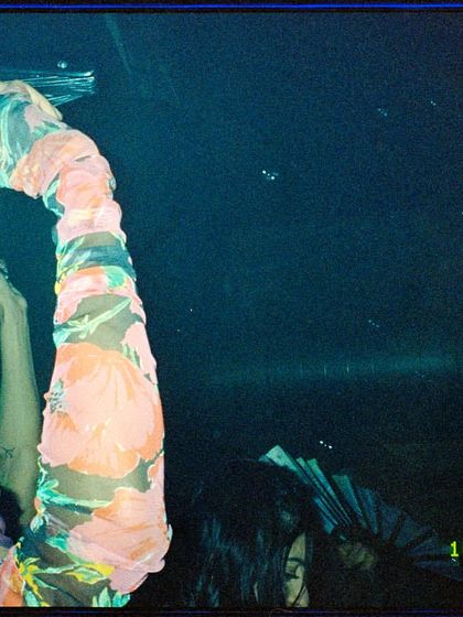 A film shot of a drag performer with their fan, a classic accessory in disco and ballroom culture. This highlights the authentic cultural elements we bring into ParaDisco.