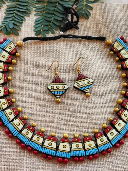 This unique choker features a geometric design with textured patterns. The combination of maroon, off-white, sky blue, and gold is both modern and elegant.