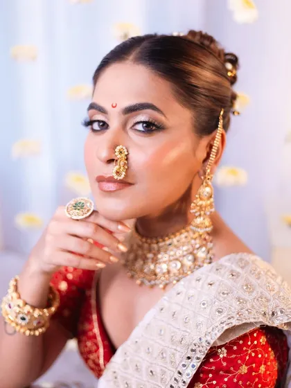 For this artistic photoshoot, we created a divine "Apsara" look. It features sharp, defined makeup with a bronzed glow, a traditional Marathi nath, and a classic bridal bun. This style is perfect for editorial shoots or for brides who want a truly royal and timeless look.