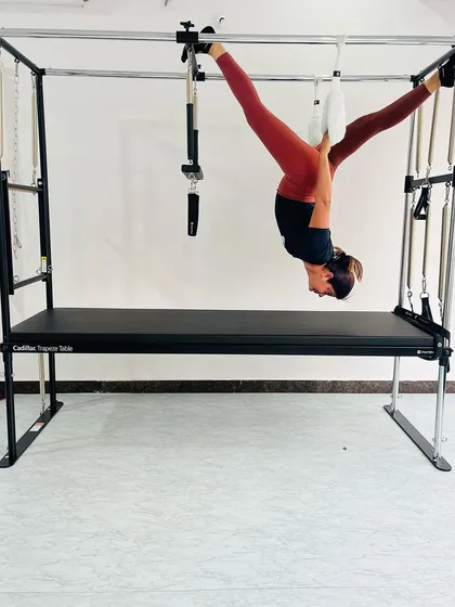 This client is performing a suspended split, an advanced move that challenges the limits of flexibility and strength.