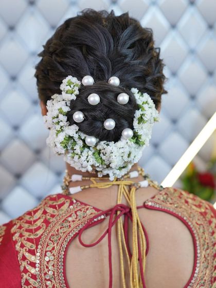 A closer look at the floral bridal bun, showing the detail of the flower and pearl arrangement.