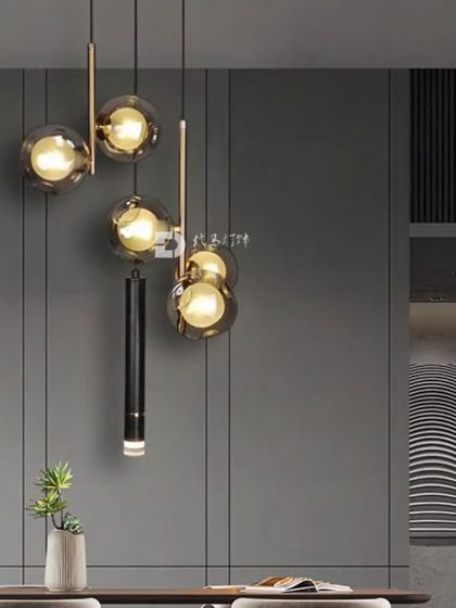 A modern cluster pendant with smoked glass globes arranged at different heights. This fixture adds a dynamic and sophisticated touch to this dining area.