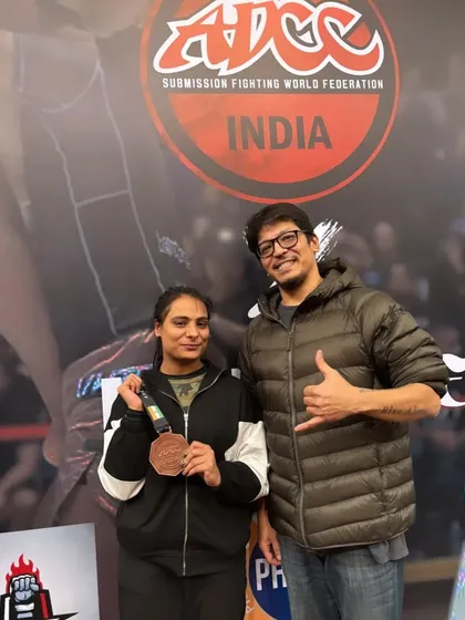 A student and coach celebrating a bronze medal win. Every competition is a learning experience, and we are proud of her for stepping up to the challenge.