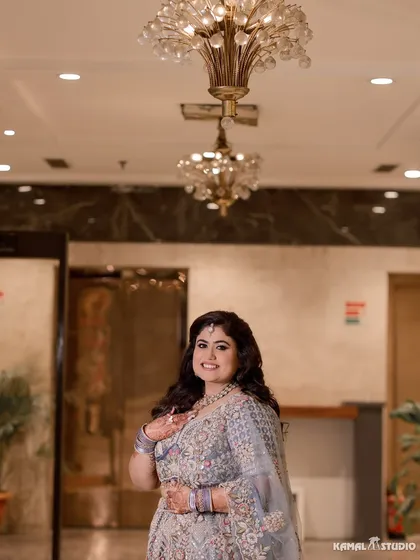 A joyful portrait of the bride at her Roka, her happy smile captured beautifully under a chandelier.