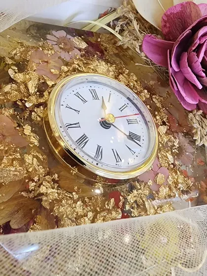 This handmade 8 inch resin desk clock is perfect for an office or side table. It's filled with beautiful dried flowers and gold flakes for an elegant touch, and the silent mechanism ensures a peaceful space.