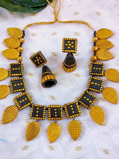 A duplicate image of the classic black and gold square and leaf necklace.
