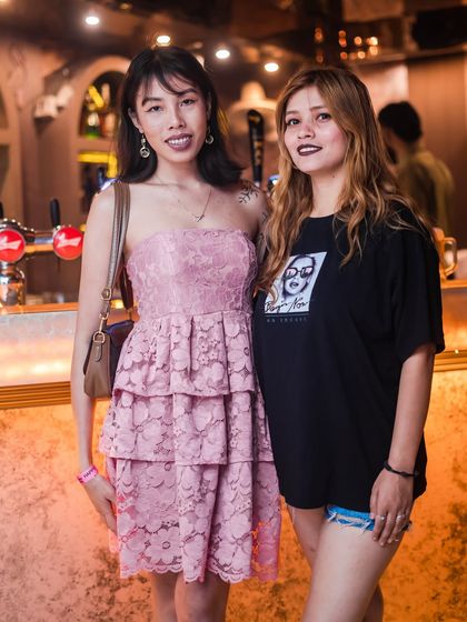 Two friends enjoying the party, one in a pink dress for the theme.