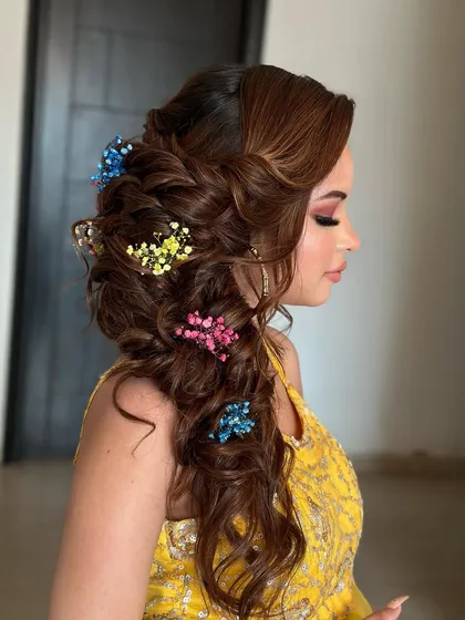 A messy, blooming braid for a Mehendi ceremony. I used colorful baby's breath to match the client's yellow outfit, creating a fun and festive look.