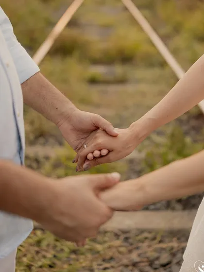 A close-up on their intertwined hands, with the engagement ring taking center stage. This detailed shot beautifully symbolizes their commitment as they embark on their new path together.