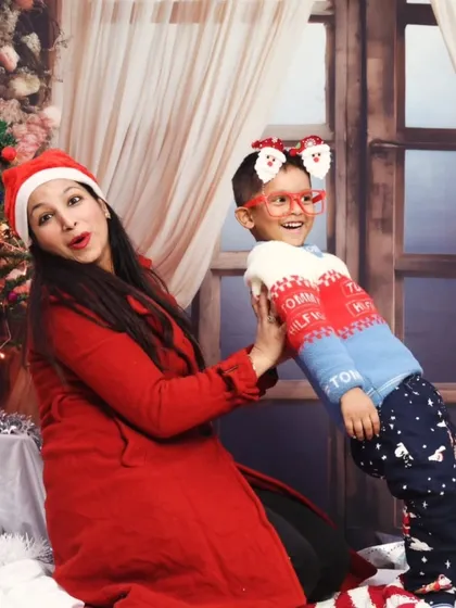A playful moment between a mother and her son during a festive Christmas photoshoot.