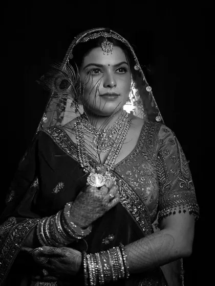 A regal black and white bridal portrait. The classic monochrome finish emphasizes the bride's traditional attire, intricate jewelry, and timeless elegance.