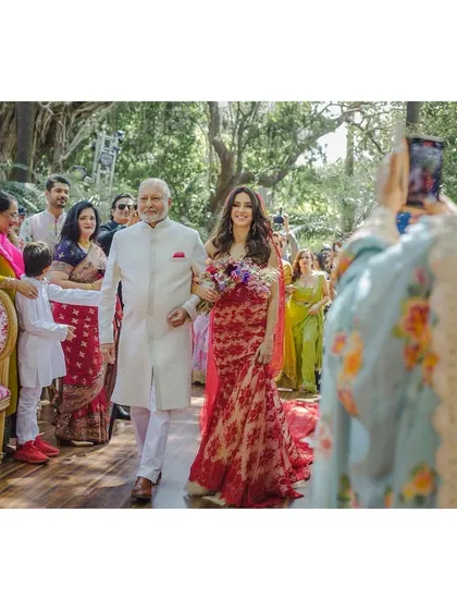 Shashi, Shibani’s dad, walks her down the aisle. The path is lined with loved ones capturing the moment on their phones, a modern take on a timeless tradition.