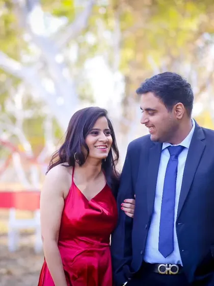 A classic walking shot from a pre-wedding session in a park. The couple looks happy and relaxed, and the beautiful natural light adds a soft, romantic quality to the photograph.