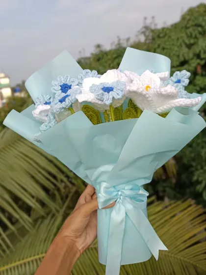 A custom bouquet of blue and white flowers, beautifully wrapped.