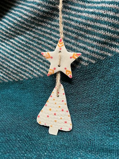 A festive pair of ornaments, one star and one tree, with delicate dot patterns.