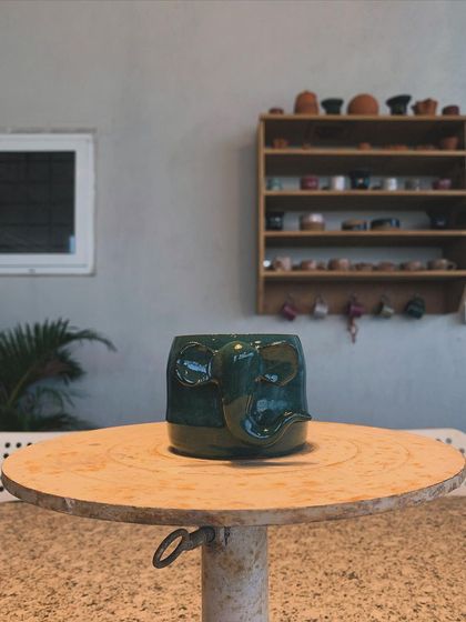 This whimsical elephant mug, with its trunk for a handle, sits on my pottery wheel. It's a playful piece that's sure to make your morning coffee a little more fun.