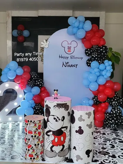 The main stage for the Mickey Mouse party, featuring a custom arch backdrop, a large light-up number '2', and themed cake stands.