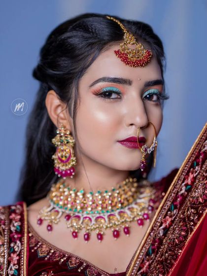 A student's creative take on a bridal look, featuring a pop of turquoise on the eyelid. This is a great example of how we can play with color for a fun event like a sangeet.