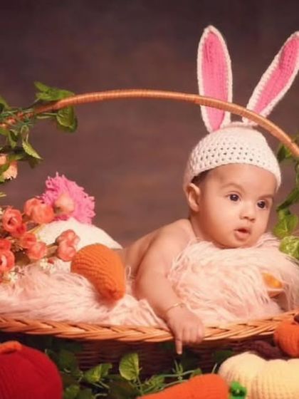 This little one is ready for an Easter-themed photoshoot. The picture features my handmade bunny ear hat and a collection of my crochet carrot and pumpkin props, all coming together to create a perfect festive scene.