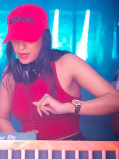 A close-up shot of me in action, focused on the mixer. The red cap adds a pop of color to the blue-lit stage.