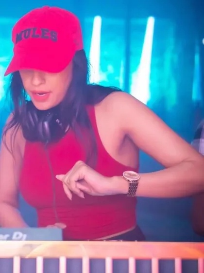 A close-up shot of me in action, focused on the mixer. The red cap adds a pop of color to the blue-lit stage.