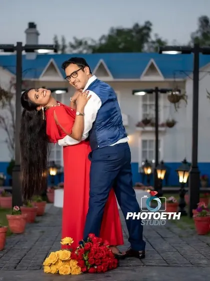 A playful and romantic dip pose in front of a charming blue and white house. This location offers a fantastic backdrop for a variety of pre-wedding shots.