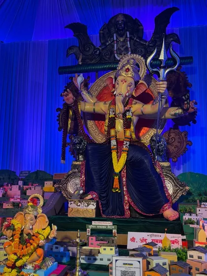 Here is another example of a themed Ganpati decoration. The backdrop and lighting create a dramatic, powerful effect, with a miniature city model at the base of the idol to tell a unique story.