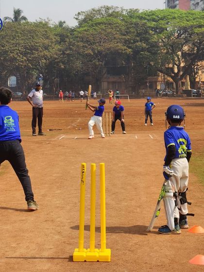 A young cricketer stands ready at the crease during a match. We provide opportunities for our junior players to experience real game scenarios on a full-sized pitch.