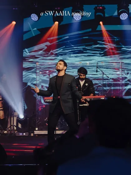 A solo artist commanding the stage with a powerful performance, set against a dynamic LED backdrop and dramatic lighting.
