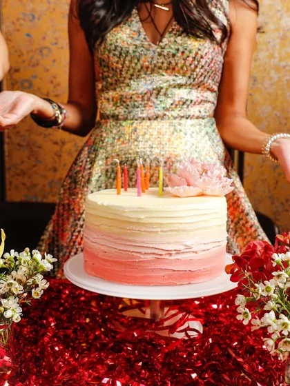Capturing the celebration. An ombre birthday cake surrounded by festive decorations, ready to be cut.