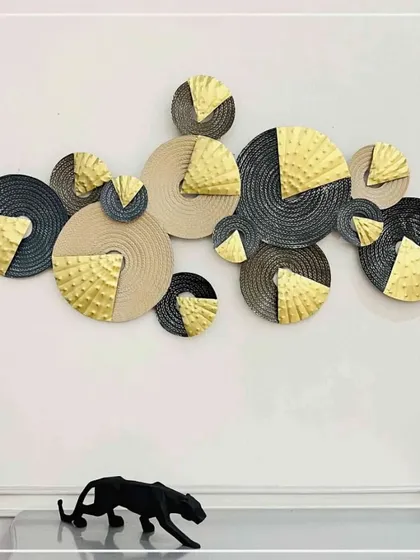 This one-of-a-kind wall decor features an abstract composition of textured discs in black, cream, and gold. The interplay of colors and textures adds a dash of contemporary and old-world charm to your living space.