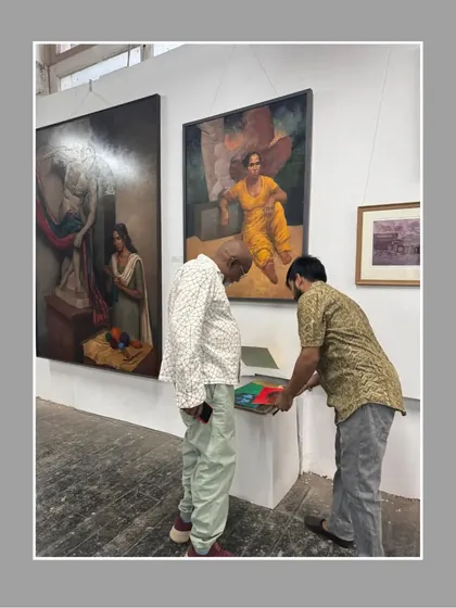Showing my portfolio to a visitor at the annual art exhibition.