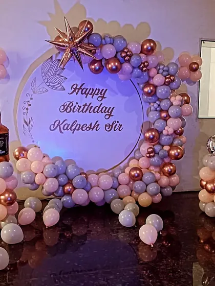 A fun adult birthday setup with a whiskey bottle foil balloon. The color palette of dusty pink, blue, and rose gold creates a unique and stylish look.