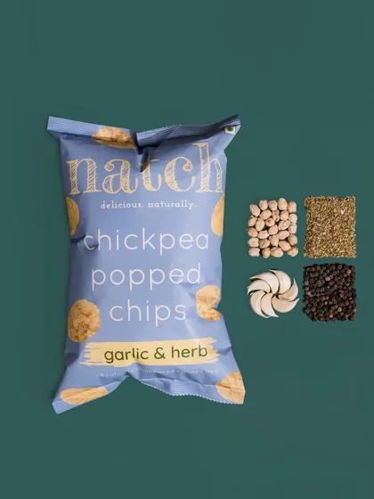 A clean and simple flatlay showing the ingredients for Natch garlic & herb chips. This style clearly communicates the product's flavor profile.