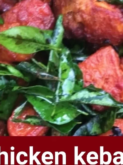 A close-up of my popular Chicken Kebab starter, garnished with fresh curry leaves.