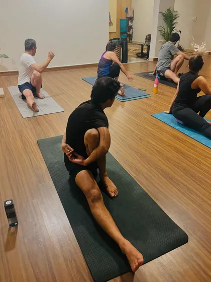 Students in Marichyasana C, a deep spinal twist. This pose detoxifies the internal organs and builds strength in the core and back.