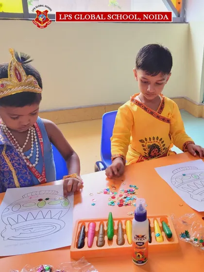Two 'Kanhas' carefully work on their Janmashtami craft, showcasing their focus and artistic skills.