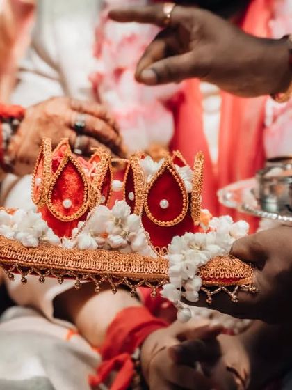 A close-up detail shot of the ceremonial crowns used in a South Indian wedding, highlighting the intricate and beautiful elements of the tradition.