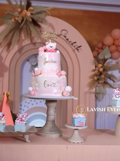 The cake and dessert table from a boho-themed party, featuring a multi-tiered cake and cupcakes all decorated to match the adorable teddy bear concept.
