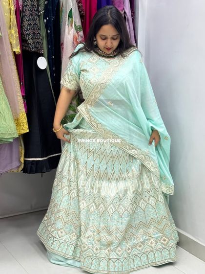 A client trying on a lovely light blue lehenga with geometric gold embroidery. This shows a real-life fitting experience in my boutique.