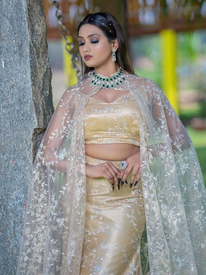 A stylish pose against a natural backdrop, this shot highlights the modern design of the cape and the sparkling jewellery.