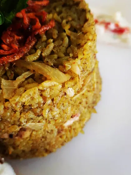 Here you can see the heart of my biriyani. Each grain of rice is coated in aromatic 'thuppa' (ghee) that I source myself from the coast, and infused with the secret spice blend that gives it a unique, peppery kick.