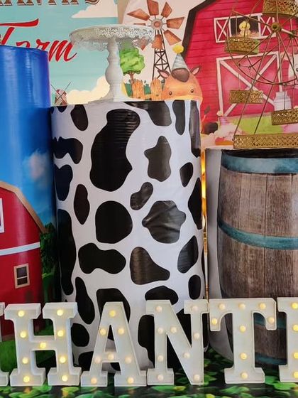 A close-up of our farm-themed decor, showcasing the custom-printed plinths with barn, cow-print, and wooden barrel designs.