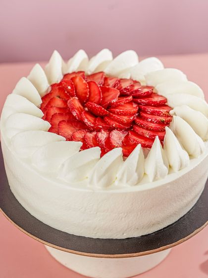 Our Strawberry Vanilla Cake, beautifully finished with piped fresh cream and sliced strawberries. This cake is available for local delivery in Mumbai.