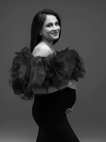 A beautiful black and white close-up, highlighting her smile and the texture of the ruffled gown.