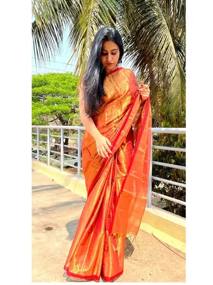 'Aarini' also comes in this radiant red and gold. This tissue cotton saree shines as bright as the sun, perfect for making a grand entrance.