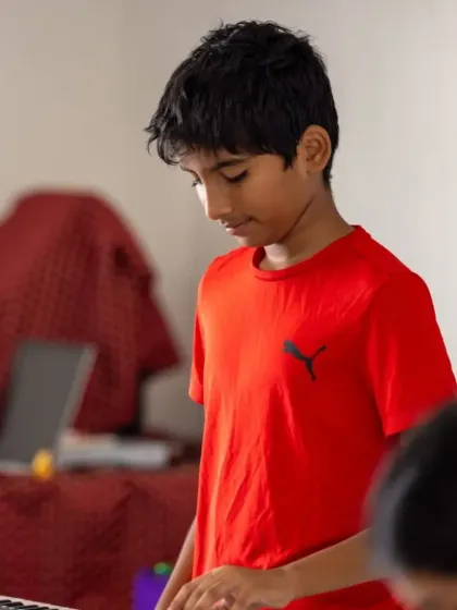 A young keyboardist concentrates on his music during the performance. Our students learn discipline and focus through these live stage experiences.