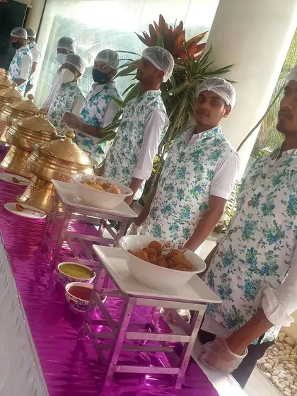 My team is the backbone of my catering service. Here they are, in uniform with hairnets and gloves, ready for service along a fully prepared buffet line. I prioritize hygiene and professionalism for every event.