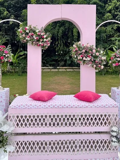 We are forever obsessed with this outdoor pink setup. The modern arches, lattice bench, and abundant floral arrangements created a stunning and romantic scene for this day wedding.